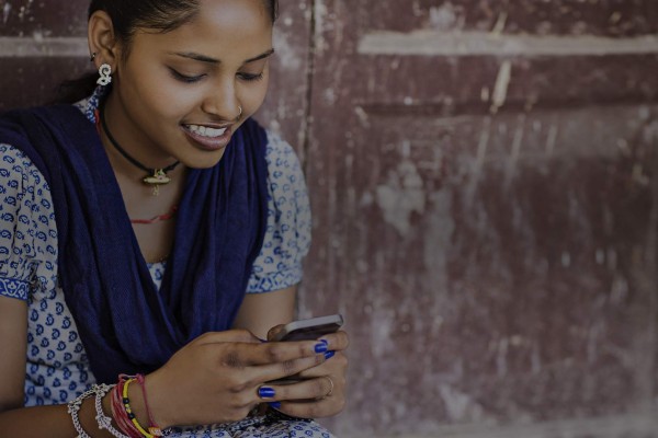 Indian girl, sitting with phone, on the internet