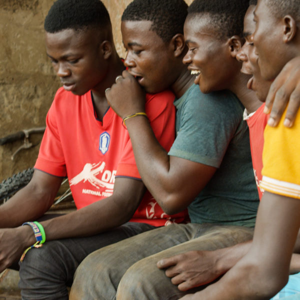 Young men from Ghana watching movies on a phone